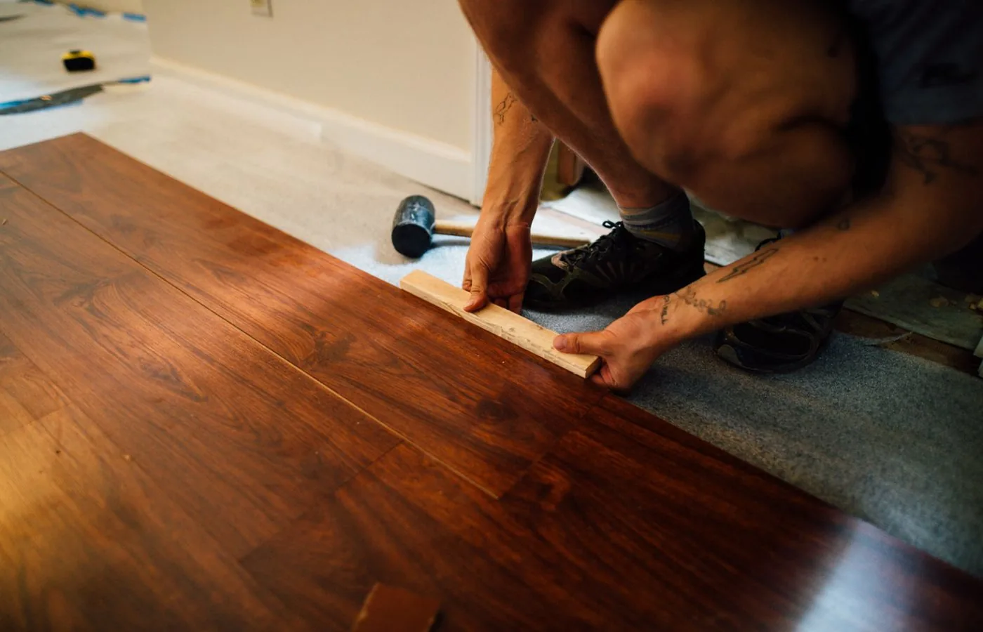 Flooring contractor installing plank flooring in a home